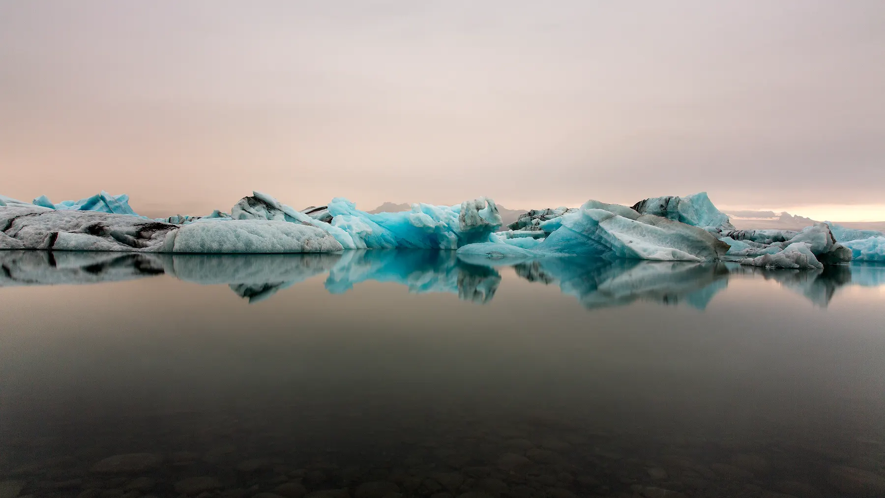 Glacial water moving between dark rock and ice